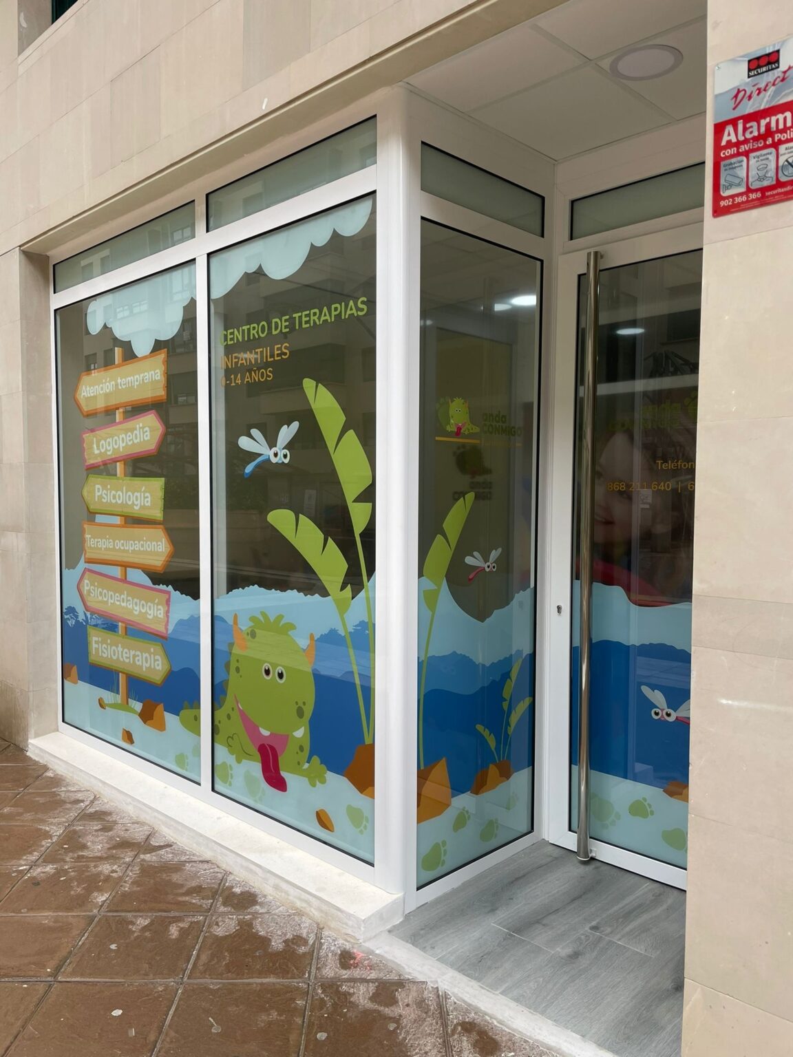 Instalador colocando vinilos en Murcia de corte con el logo corporativo en una pared interior