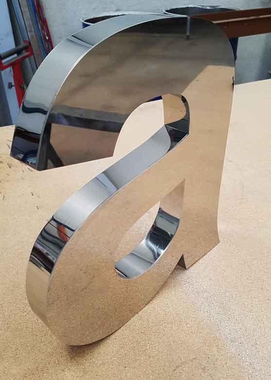 Montaje de letras corpóreas en Murcia de aluminio con retroiluminación LED en la fachada de una tienda.